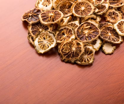Pile of dried lime slices on wooden table