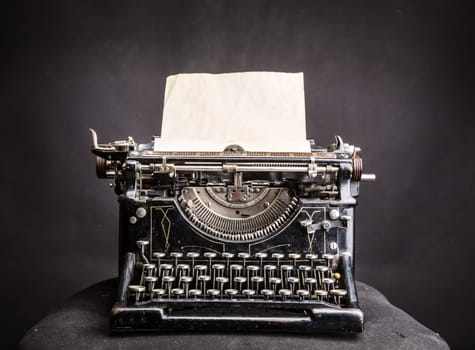 Vintage black typewrite with inserted paper sheet. Antique type writer