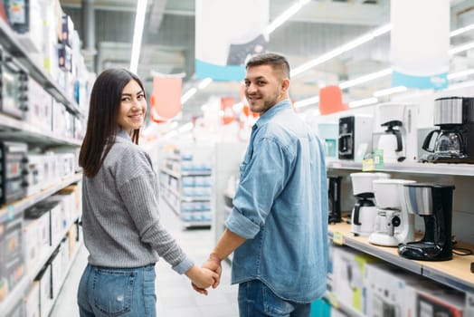 Couple in department of household appliances, market. Customers in shop, family choosing consumer goods