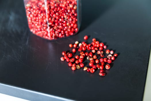 Dried red berries in glass jar and on the table