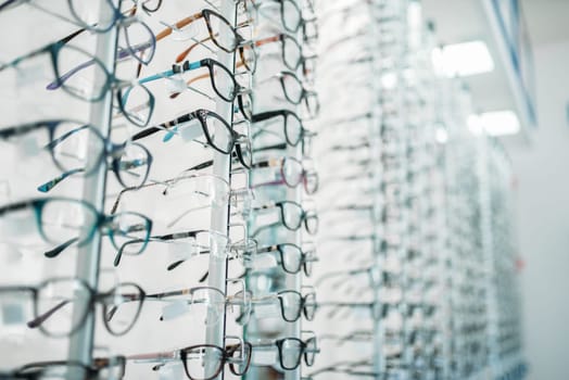 Eyeglasses and sunglasses showcase in optic shop, nobody. Eye vision protection, optical store accessory on shelves