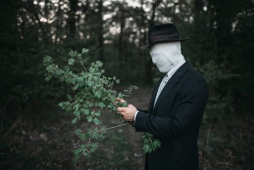 Serial maniac in the forest, face wrapped in bandages, bloody killer concept, crazy murderer, crime and violence horror
