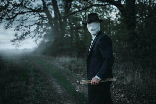 Serial maniac with axe in the forest, face wrapped in bandages, bloody killer concept, crazy murderer, crime and violence horror
