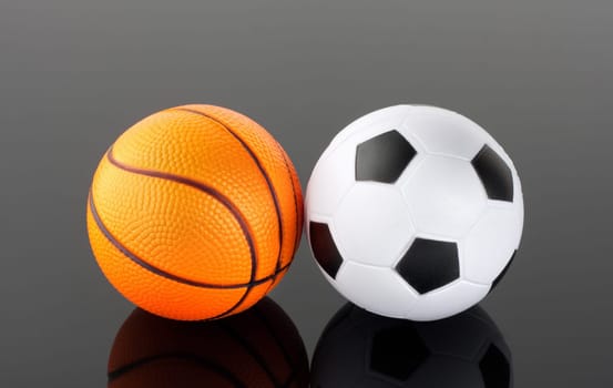 Close-up of classic basketball and football with reflection in mirror