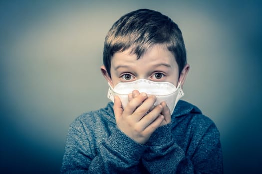 child with face mask wraps his hands over his mouth. virus prevention concept. Corona virus. Medical prevention and health.