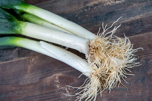 Fresh raw leeks on the wooden table