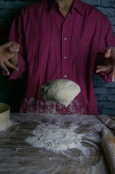 Women's hands mix the dough on a wooden table. Preparing bread for baking. Front views