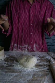 Women's hands mix the dough on a wooden table. Preparing bread for baking. Front views