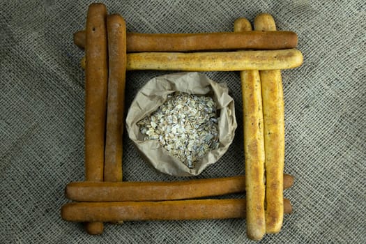 A pile of breadsticks or grissini in the shape of a square, inside an open glacier. Top views