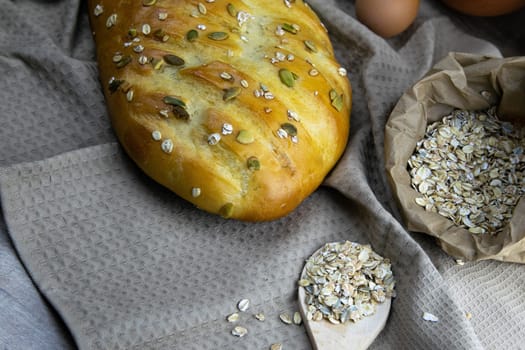 Concept shot of spice bread sticks with a wooden spoon on the wood table, oatmeal and a skein of bag thread, egg, flour, seeds and nuts. Front views