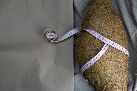 Concept shot of spice bread sticks with a wooden spoon on the wood table, oatmeal and a skein of bag thread, egg, flour, seeds and nuts. Front views
