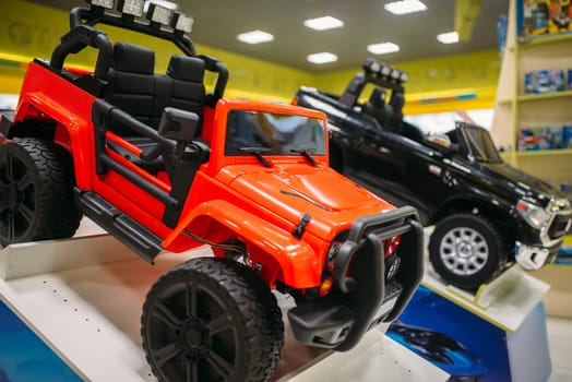 Electric car on showcase in toy store, nobody. Toyshop interior, motor automobile for children