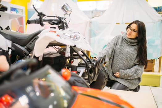 Pregnant woman choosing electric car in toy store, nobody. Toyshop interior, motor automobile for children