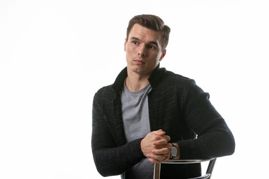 The young guy thought hard, sitting on a chair