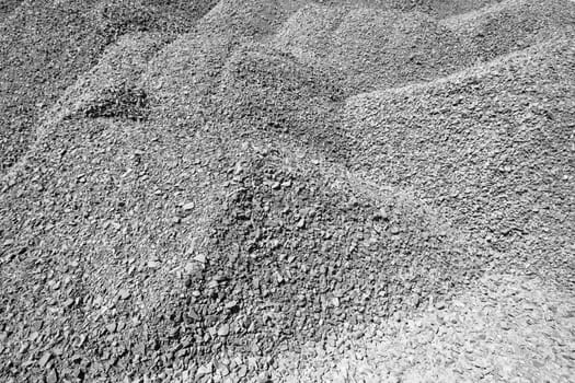 Raw stone piles in black white background detail from quarry for concrete mixing on construction
