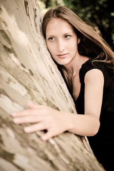 Young woman huging trunk of tree - love to nature