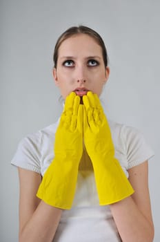 Young woman wearing yellow work gloves with thoughtful expression