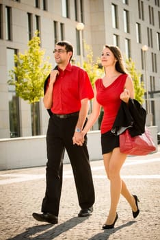Young smiling business people in red walking street after their work