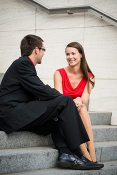 Colleagues - young business people having conversation sitting on stairs