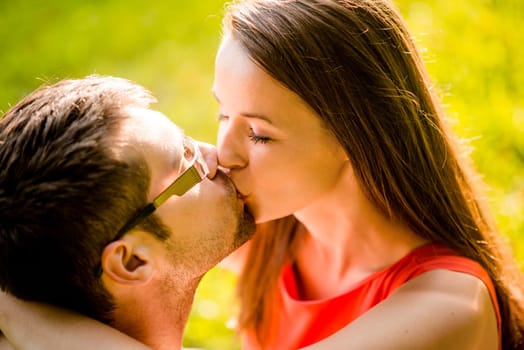 Romantic young couple hugging and kissing in nature