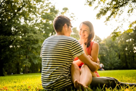 Young couple dating and hugging in nature - shot against direct sun