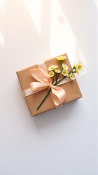 The gift is packaged in minimalist packaging, decorated with a neutral, calm ribbon in nude tones and flowers symbolizing the arrival of spring. High quality photo