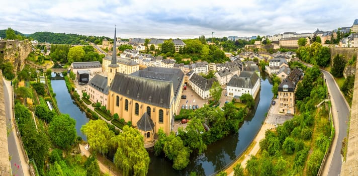 Luxembourg cityscape, ancient church on river, panorama. Old european architecture, medieval stone buildings, benelux country