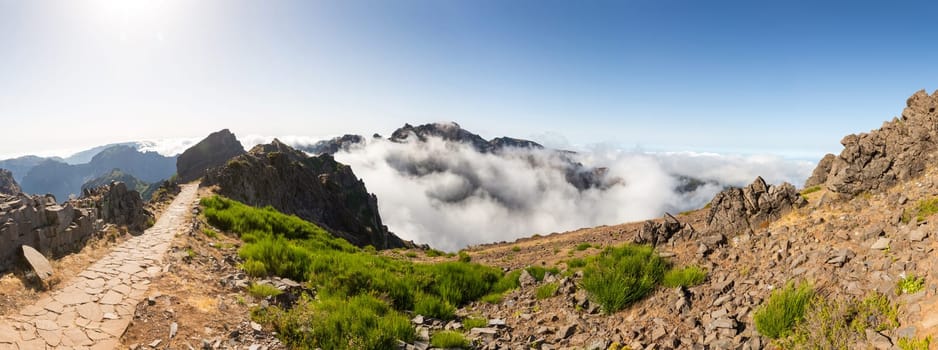 Panoramic view of hiking track high in mountains above the clouds