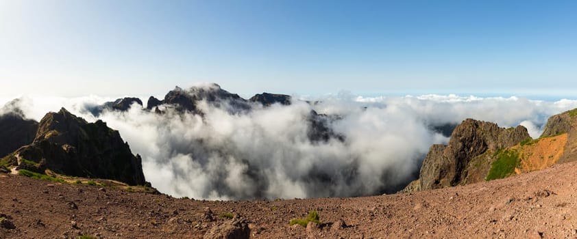 Panoramic view of high mountains above the clouds