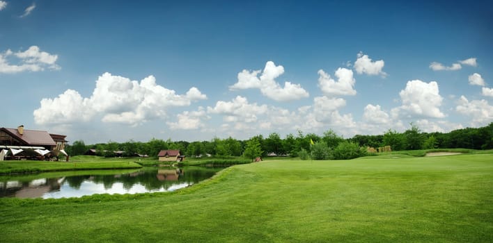 Green field and lake for golfing, golf course, nobody. Meadow in sport club, playground at sunny day, beautiful landscape for summer leisure