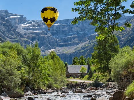 a view of Cirque de Gavarnie with yellow hot air balloon, Hautes-Pyrenees, France