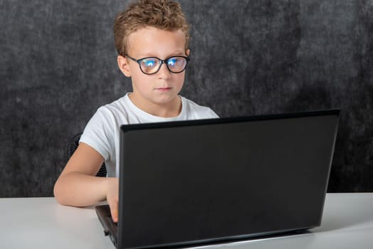 Happy boy sitting with a laptop computer