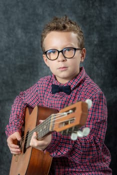 a caucasian boy playing on acoustic guitar