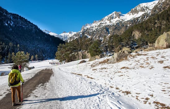 hiker woman walking on the snowy Pyrenees mountains, France