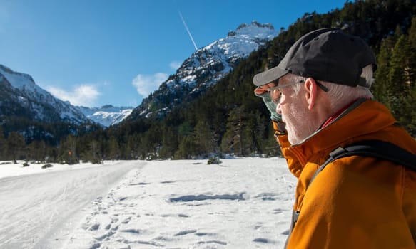 hiker man looking the snowy Pyrenees mountains, Cauterets, France