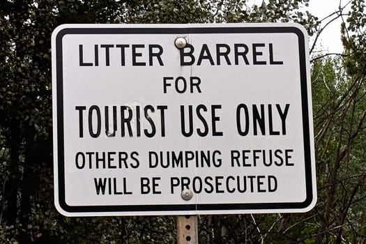 A litter barrel for tourist use only sign.
