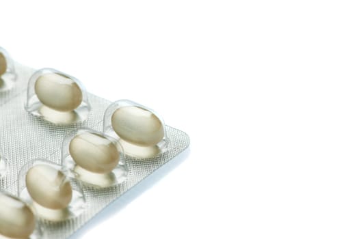 Partial view of a foil packaging for tablet dragees isolated on white background with slight bottom shadow.