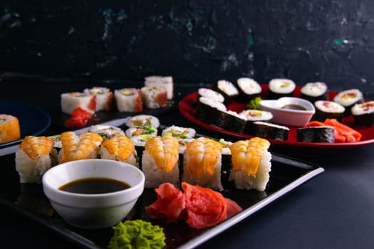 Top view of wooden platter with great set of delicious Nigiri sushi and Tempura rolls with Maki and Uramaki rolls on an orange background. Front views