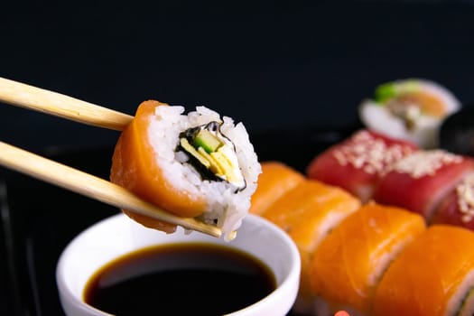 Top view of wooden platter with great set of delicious Nigiri sushi and Tempura rolls with Maki and Uramaki rolls on an rad background. Top views