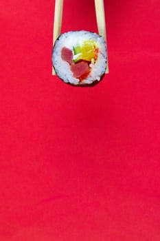 Top view of wooden platter with great set of delicious Nigiri sushi and Tempura rolls with Maki and Uramaki rolls on an rad background. Top views