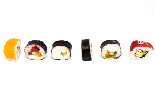 A set of rolls of different kinds with sushi sticks isolated on a black background. Top views