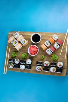 A set of rolls of different kinds with sushi sticks isolated on a black background. Top views