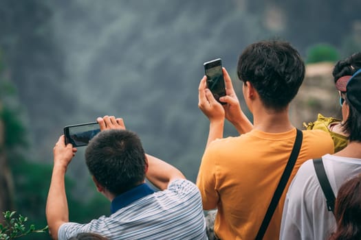 Zhangjiajie, China - August 2019 : Tourists taking pictures on mobile phones on the viewpoint in Tianzi mountain range, Avatar mountains nature park