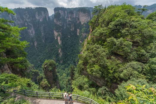 Zhangjiajie, China - August 2019 : Tourists taking pictures on mobile phones on the  Enchanting terrace viewpoint, Avatar mountains nature park