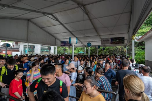 Zhangjiajie, China - August 2019 :  Massive tourist crowds in a extremely long queue to the Wellingyuan entrance of the Zhangjiajie National Park, Hunan Province