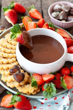 Chocolate fondue with fresh strawberries and cookies