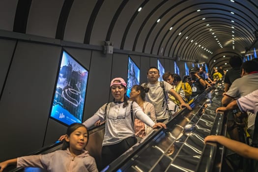 Zhangjiajie, China - August 2019 : Crowd of people transported via moving stair escalator cut inside the rock to the top of the famou Tianmen Shan mountain