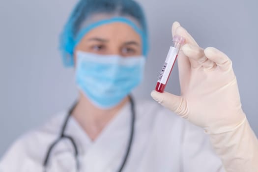 Nurse holding test blood sample. Virus test and research concept. Focus is on blood test tube.