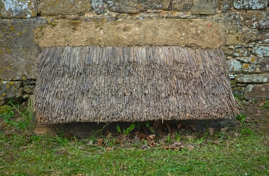 Old style cane canopy next to an stone wall