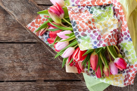 Fresh colorful tulips on a rustic wooden background